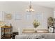 Cozy dining area featuring a modern chandelier, white chairs, and a bar cart, perfect for entertaining at 5108 Molveno Ct, Las Vegas, NV 89130