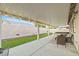 Relaxing covered patio with outdoor seating, a hot tub, and a well-kept artificial turf area at 5108 Molveno Ct, Las Vegas, NV 89130