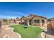 Charming backyard features artificial turf, a patio, swing set and privacy fence, creating a private oasis at 5687 Harbour Pointe Ave, Las Vegas, NV 89122
