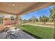 Relaxing backyard with artificial turf, a covered patio, a swing set, and golf course views at 5687 Harbour Pointe Ave, Las Vegas, NV 89122