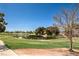 Scenic golf course view with lush green grass, mature trees, and a serene pond under a clear blue sky at 5687 Harbour Pointe Ave, Las Vegas, NV 89122
