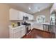 Bright kitchen featuring white cabinets, stainless appliances, wood floors, and granite countertops at 5687 Harbour Pointe Ave, Las Vegas, NV 89122