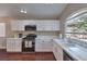 Bright kitchen featuring white cabinets, stainless appliances, wood floors, and granite countertops at 5687 Harbour Pointe Ave, Las Vegas, NV 89122