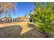 A backyard area with a patch of dry grass and small trees providing shade at 5825 Bent Branch Ln, Las Vegas, NV 89142