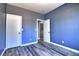 Bedroom featuring neutral walls, gray laminate floors, and a doorway to the laundry room at 6042 Thorne Bay Ct, Las Vegas, NV 89110