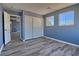 A cozy bedroom with laminate floors, large windows, and a spacious closet at 6042 Thorne Bay Ct, Las Vegas, NV 89110