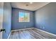 Bedroom featuring neutral walls, gray laminate floors, and a window providing natural light at 6042 Thorne Bay Ct, Las Vegas, NV 89110