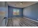 Bedroom featuring blue walls, luxury vinyl plank flooring, natural light and a window with blinds at 6042 Thorne Bay Ct, Las Vegas, NV 89110