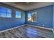 This is a cozy bedroom that features three windows and beautiful laminate flooring at 6042 Thorne Bay Ct, Las Vegas, NV 89110