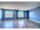 Bonus room featuring neutral walls, gray laminate floors, and two large windows at 6042 Thorne Bay Ct, Las Vegas, NV 89110
