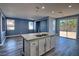 A modern kitchen features granite counters, a kitchen island, stainless appliances, and a sliding glass door at 6042 Thorne Bay Ct, Las Vegas, NV 89110