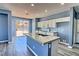 A modern kitchen features granite counters, a kitchen island, stainless appliances, and backyard access at 6042 Thorne Bay Ct, Las Vegas, NV 89110