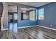 A living room with great light, wood look flooring and blue paint with openings to other rooms at 6042 Thorne Bay Ct, Las Vegas, NV 89110