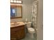 Traditional bathroom with a light countertop vanity, blue tiled floor and shower with patterned curtain at 6241 Pinewood Ave, Las Vegas, NV 89103
