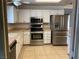 Well-equipped kitchen with stainless steel appliances, white cabinets, and a tiled floor at 6241 Pinewood Ave, Las Vegas, NV 89103