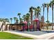 Community playground with slides and palm trees, offering a fun recreational space for residents at 66 John Stuart Mill St, Henderson, NV 89002