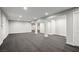 Finished basement with neutral carpet, featuring support columns, and doors to storage spaces at 7060 W Rome Blvd, Las Vegas, NV 89131