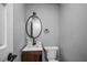 Cozy bathroom featuring an oval mirror, wood vanity, and a modern black faucet at 7060 W Rome Blvd, Las Vegas, NV 89131
