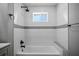 Modern bathroom with gray tile flooring, textured white walls, matte black fixtures, and sleek tub/shower at 7060 W Rome Blvd, Las Vegas, NV 89131