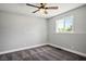 This bedroom has gray carpet, gray walls, a window, and a ceiling fan at 7060 W Rome Blvd, Las Vegas, NV 89131