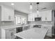 Modern kitchen featuring white cabinets, quartz countertops, stainless appliances, and stylish pendant lighting at 7060 W Rome Blvd, Las Vegas, NV 89131
