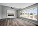 This living room includes a large window, a fireplace, hard floors, and a ceiling fan at 7060 W Rome Blvd, Las Vegas, NV 89131