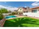 Well-maintained backyard showcasing a refreshing swimming pool, green lawn, and cozy outdoor seating at 7384 Valhalla Ln, Las Vegas, NV 89123