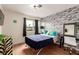 Comfortable bedroom with brick accent wall, hardwood floors, and modern decor at 7384 Valhalla Ln, Las Vegas, NV 89123