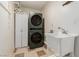 Laundry room featuring a stackable washer and dryer, and a utility sink at 7384 Valhalla Ln, Las Vegas, NV 89123