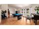 An open-concept living area features a billiard table and hardwood floors with stairs nearby at 7384 Valhalla Ln, Las Vegas, NV 89123