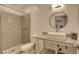 Bright bathroom featuring a shower, toilet, and floating vanity sink with granite countertop at 7590 Rancho Destino Rd, Las Vegas, NV 89123
