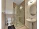 A bright bathroom featuring a modern shower and pedestal sink with a round mirror at 7590 Rancho Destino Rd, Las Vegas, NV 89123