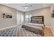 Modern bedroom with a ceiling fan, wood-look floors, and a stylish gray patterned rug at 7590 Rancho Destino Rd, Las Vegas, NV 89123