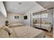 Bright bedroom with two beds, mirrored closet doors, and a wall-mounted TV at 7590 Rancho Destino Rd, Las Vegas, NV 89123