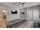 A modern bedroom with a tv, gray rug and a view into the attached bathroom at 7590 Rancho Destino Rd, Las Vegas, NV 89123