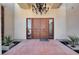 Close-up of the double wooden front doors with a decorative chandelier, inviting guests into the home at 7590 Rancho Destino Rd, Las Vegas, NV 89123
