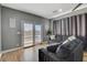 Cozy living room features hardwood floors, comfortable seating, and sliding glass door to patio at 7590 Rancho Destino Rd, Las Vegas, NV 89123