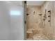 Luxurious walk-in shower with travertine tile, a built-in bench, and multiple shower heads at 7590 Rancho Destino Rd, Las Vegas, NV 89123