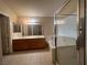 Bathroom featuring a double sink vanity, tile floors, and shower with glass door at 7641 Tortola Bay Ln, Las Vegas, NV 89128