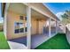 This backyard features an artificial turf lawn, block walls, and a covered patio with fan at 7816 Calico Flower Ave, Las Vegas, NV 89128