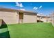 This backyard features an artificial turf, block walls, and access to a covered patio at 7816 Calico Flower Ave, Las Vegas, NV 89128