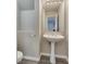 Small bathroom with pedestal sink, tile floors, and decorative mirror at 7816 Calico Flower Ave, Las Vegas, NV 89128