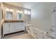 Bright bathroom features double sinks, marble tile, soaking tub, and sleek glass shower at 7816 Calico Flower Ave, Las Vegas, NV 89128
