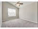 Carpeted bedroom with a ceiling fan, a large window, and neutral paint color at 7816 Calico Flower Ave, Las Vegas, NV 89128