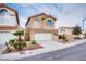 Charming two-story home with tile roof, desert landscaping, two car garage, and mature palm tree at 7816 Calico Flower Ave, Las Vegas, NV 89128