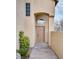 This charming front door features an arched entryway, a small garden, and a large window at 7816 Calico Flower Ave, Las Vegas, NV 89128