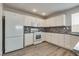 Bright kitchen featuring white cabinetry, stone backsplash, and stainless steel appliances at 7816 Calico Flower Ave, Las Vegas, NV 89128