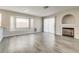 Open floor plan features modern grey floors, fireplace, window bench and sliding glass door at 7816 Calico Flower Ave, Las Vegas, NV 89128