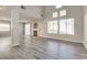 Bright living room featuring fireplace, large windows, and modern, grey wood flooring at 7816 Calico Flower Ave, Las Vegas, NV 89128