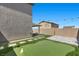 Backyard with artificial turf, a putting green, covered patio and decorative string lights at 9054 Tangerine Tree Ct, Las Vegas, NV 89113